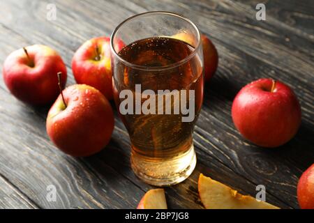 Komposition mit Apfelwein und Äpfeln auf Holzhintergrund Stockfoto