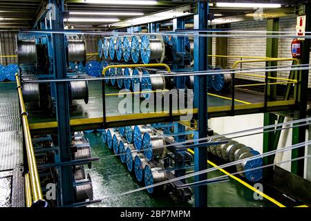 Johannesburg, Südafrika - 16. Oktober 2012: Weitwinkelansicht von Kabelspulen auf einer großen Maschine in einer Förderbandfabrik Stockfoto