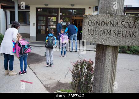 Die Kinder warten in sicherer Entfernung voneinander, um in eine Grundschule zu gelangen.die Schüler der ersten drei Jahre der Grundschulen sowie der letzten Schuljahre der Sekundarschulen in Slowenien kehren nach zwei Monaten der durch die Coronavirus-Epidemie (Covid-19) verursachten Blockade in die Schulen zurück. Stockfoto