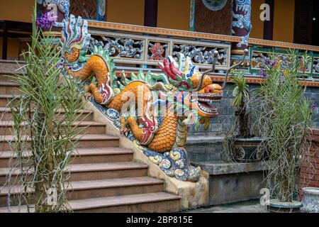 Bunte Drachen-Skulptur am Eingang zu einem buddhistischen Tempel auf der Treppe in der Stadt Danang, Vietnam. Nahaufnahme Stockfoto