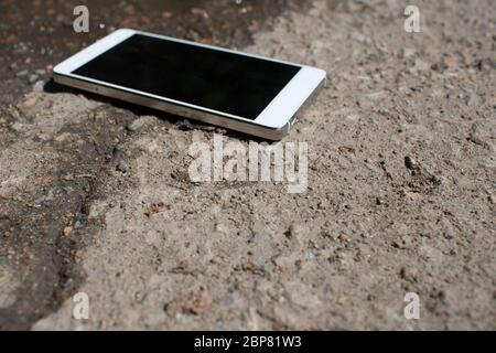 Handy liegt auf Asphalt Stockfoto