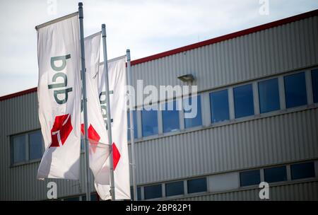 18. Mai 2020, Nordrhein-Westfalen, Hückelhoven-Hilfarth: Vor leeren Büros in den Räumlichkeiten des Paketzustellers DPD winken Fahnen mit dem DPD-Logo. Das Logistikunternehmen hat seinen Standort in Hückelhoven im Kreis Heinsberg mit 400 Mitarbeitern aufgrund eines Corona-Ausbruchs vorübergehend geschlossen. Foto: Jonas Güttler/dpa Stockfoto