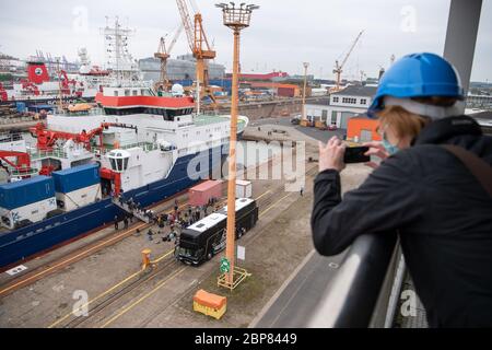 Bremerhaven, Deutschland. Mai 2020. Eine Frau fotografiert die Expeditionsteilnehmer beim Start der deutschen Forschungsschiffe 'Maria S. Merian' (vorne) und 'Sonne'. Zwei Forschungsschiffe starten von Bremerhaven in Richtung Arktis. An Bord sind etwa 100 Wissenschaftler, die das derzeitige Personal des Eisbrechers Polarstern ersetzen sollen. Das neue Team hatte die letzten zwei Wochen wegen der Corona-Pandemie in Bremerhaven in Quarantäne verbracht. Quelle: Sina Schuldt/dpa/Alamy Live News Stockfoto