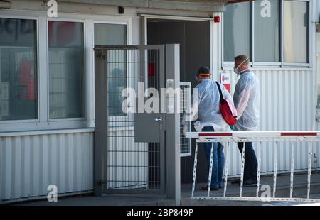 18. Mai 2020, Nordrhein-Westfalen, Hückelhoven-Hilfarth: Zwei Mitarbeiter eines Desinfektionsdienstes betreten das Gebäude des Paketzustellers DPD mit Schutzausrüstung. Das Logistikunternehmen hat seinen Standort in Hückelhoven im Kreis Heinsberg mit 400 Mitarbeitern aufgrund eines Corona-Ausbruchs vorübergehend geschlossen. Foto: Jonas Güttler/dpa Stockfoto