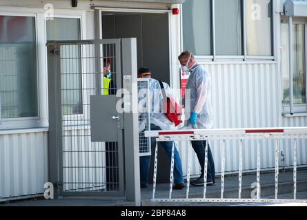 18. Mai 2020, Nordrhein-Westfalen, Hückelhoven-Hilfarth: Zwei Mitarbeiter eines Desinfektionsdienstes betreten das Gebäude des Paketzustellers DPD mit Schutzausrüstung. Das Logistikunternehmen hat seinen Standort in Hückelhoven im Kreis Heinsberg mit 400 Mitarbeitern aufgrund eines Corona-Ausbruchs vorübergehend geschlossen. Foto: Jonas Güttler/dpa Stockfoto