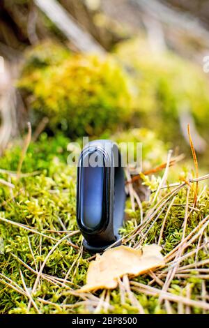 Schwarz und blau Fitness-Tracker auf Wald Hintergrund. Fitness Armband für das Sporttraining. Stockfoto