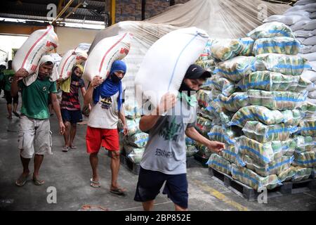Jakarta, Indonesien. Mai 2020. Arbeiter tragen Reissäcke, die in Lebensmittelverpackungen für bedürftige Familien in einem Lager in Jakarta, Indonesien, 18. Mai 2020 verwendet werden. Indonesische Beamte haben geschworen, im Zuge des Ausbruchs der COVID-19 und der anhaltenden Trockenzeit eine ausreichende Nahrungsmittelversorgung für die Menschen im ganzen Land sicherzustellen. Kredit: Zulkarnain/Xinhua/Alamy Live News Stockfoto