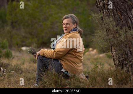 Ältere Frau sitzt nach einem Spaziergang im Heiligtum der Barmherzigkeit, in der Nähe von Borja, in der Provinz Zaragoza, Spanien. Stockfoto