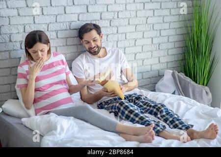 Junge schwangere Frau in einem gestreiften T-Shirt Gefühl Übelkeit nach dem Essen Stockfoto