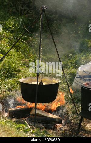 Sibiu County, Rumänien. Kochen Polenta im Freien in großen Kessel hängen über dem Feuer. Stockfoto