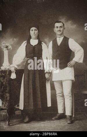 Kopie eines 100 Jahre alten B&W-Fotos, das Rumänen aus dem Landkreis Sibiu (Siebenbürgen) in traditioneller Kleidung porträtiert Stockfoto