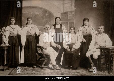 Kopie eines 100 Jahre alten B&W-Fotos, das Rumänen aus dem Landkreis Sibiu (Siebenbürgen) in traditioneller Kleidung porträtiert Stockfoto