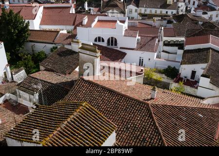 Blick aus der Vogelperspektive auf die traditionellen verfallenen Dächer Mauern und Höfe im Zentrum der historischen Altstadt von Evora in Portugal Stockfoto