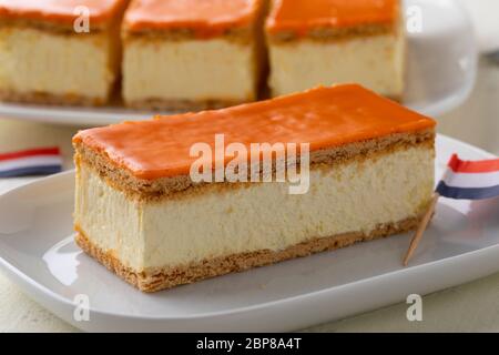 Traditionelles holländisches Orange Tompouce Gebäck für den Königstag mit holländischer Flagge auf dem Hintergrund Stockfoto