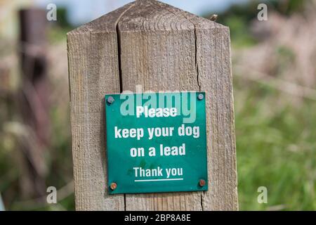 Sign on post to Dog owners, Hinweis, um ihren Hund an der Leine zu halten, wenn auf dem Land, Großbritannien. Landschaftliches Kodex, Konzept der Verantwortung. Stockfoto