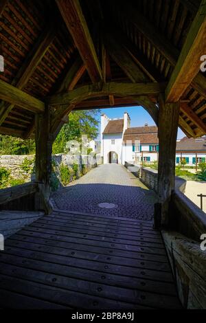 Überdachte Holzbrücke über Kill Zone, die zum Zwingen Schloss führt. Gemeinde im Landkreis Laufen im Kanton Basel-Land in der Schweiz. Stockfoto