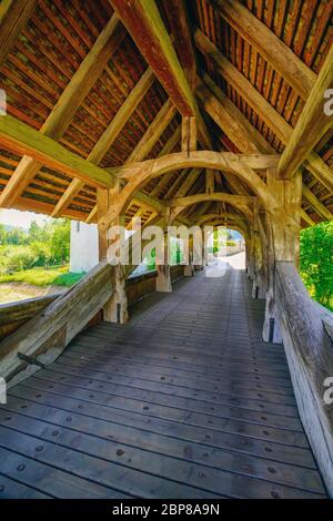 Überdachte Holzbrücke über Kill Zone, die zum Zwingen Schloss führt. Gemeinde im Landkreis Laufen im Kanton Basel-Land in der Schweiz. Stockfoto