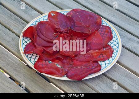 Ein Teller mit Scheiben von bresaola, italienisches getrocknetes Rindfleisch Stockfoto