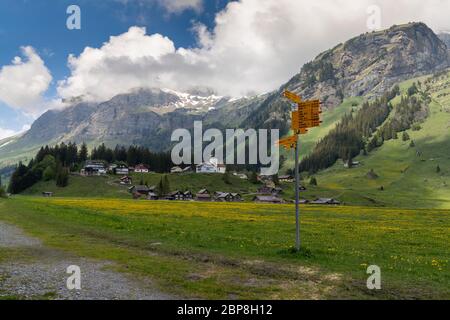Urnerboden, UR / Schweiz - 17. Mai 2020: Blick auf das Dorf Urnerboden hoch oben in den Schweizer Alpen im Kanton Uri mit Wandermarkierungen Stockfoto
