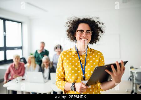 Porträt des Lehrers mit Senioren, die Computer und Technologie-Bildung Klasse. Stockfoto