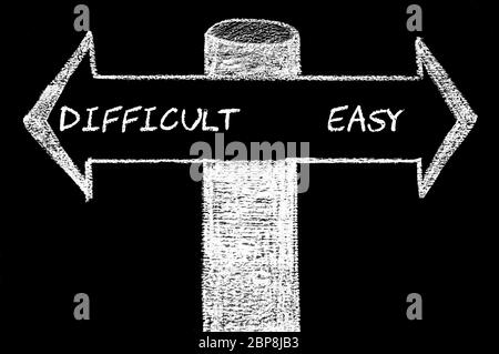 Gegenüber Pfeile mit schwer im Vergleich zu Easy. Handzeichnung mit Kreide auf die Tafel. Andere Wahl Konzeptbild Stockfoto