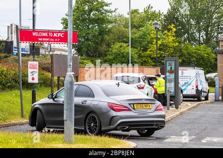 Irvine, Großbritannien. Mai 2020. KFC (Kentucky Fried Chicken) Fast Food Outlet stellte seinen Mitarbeitern PSA zur Verfügung und eröffnete es Drive Thru Facility, was sich bei Käufern aus dem nahe gelegenen Einkaufszentrum als sehr beliebt erweist. Das Restaurant ist Ende März geschlossen und wartet auf Anweisungen der schottischen Regierung, wann sie die Sitzmöglichkeit eröffnen können. Kredit: Findlay/Alamy Live News Stockfoto