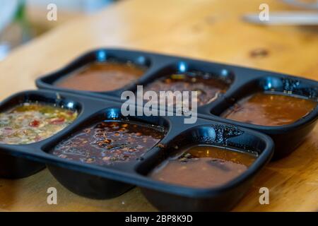 Die würzigen Saucen und Würzmittel für Shabu in Tasse Sauce auf einem Holztisch Hintergrund.Dipping Sauce für Shabu. Stockfoto