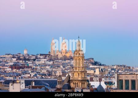 Luftaufnahme der Basilika Sacre-Coeur oder Basilika des Heiligen Herzens Jesu in der butte Montmartre und der Kirche der Heiligen Dreifaltigkeit bei Sonnenuntergang, Paris, Frankreich Stockfoto