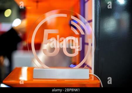 5g weißes Symbol auf transparenten Kunststoffen. Orangefarbener Hintergrund in Unschärfe. Nahaufnahme, Vorderansicht Stockfoto
