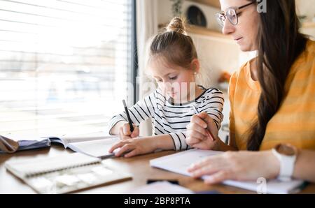 Mutter und Tochter lernen zuhause, Corona-Virus und Quarantäne-Konzept. Stockfoto