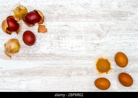 Sechs Ostereier natürlich gefärbt in Zwiebel Schalen und Gelbwurz auf weiße Eiche Hintergrund, Ansicht von oben Stockfoto