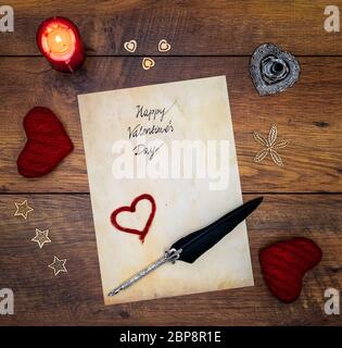 Antike Vorzeichen mit geschriebenem Happy Valentines Day, rote Kerze, 2 Kuschelherzen, bemalte hart, Holzdekorationen, detaillierte silberne kiel Stand, orna Stockfoto