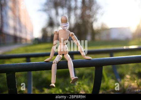 Holzpuppe mit Gesichtsmaske in der Natur, Corona-Virus und Lockdown-Konzept. Stockfoto