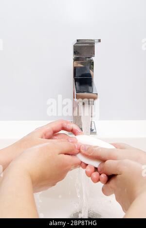 Kinder waschen Hände mit Seife unter dem Kran mit Wasser. Nahaufnahme. Körperhygiene-Konzept Stockfoto