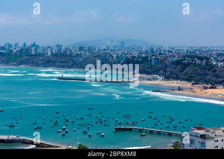 Luftaufnahme des Strandes in der Stadt Lima, Peru. Einige Docks und Boote auf dem blauen Meer Stockfoto