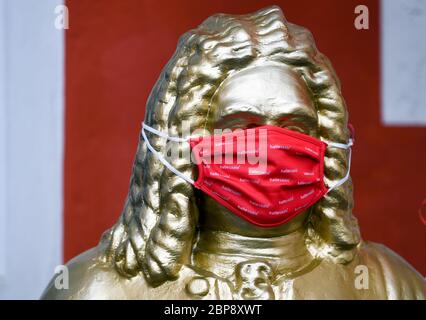 18. Mai 2020, Sachsen-Anhalt, Halle (Saale): Eine Skulptur auf dem Markt in Halle/Saale, die den aus Halle stammenden Georg Friedrich Händel zeigt, trägt eine Mund-Nase-Maske mit dem Stadtlogo. Foto: Hendrik Schmidt/dpa-Zentralbild/dpa Stockfoto