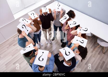 Gruppe von multi-ethnischen Menschen standen im Kreis mit Fragezeichen Zeichen über dem Kopf Stockfoto