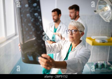 Ärzte des medizinischen Teams überprüfen die Röntgenergebnisse im Krankenhaus Stockfoto