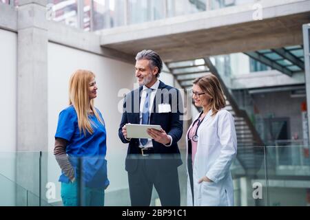 Gruppe von Ärzten im Gespräch mit einem pharmazeutischen Vertriebsmitarbeiter. Stockfoto