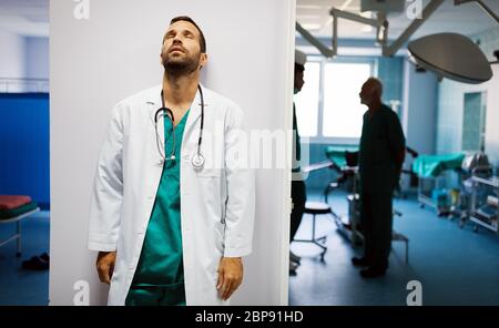 Chirurg, Arzt Mann nach einer Operation. Müde, überarbeitet, Menschen, Krankenhauskonzept. Stockfoto