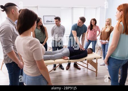 Männliche Kursleiter Lehre Massagetechnik zur Gruppe der multi-ethnischen Menschen Stockfoto