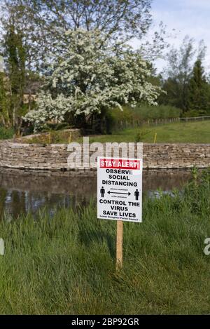 Bleiben Sie wachsam, beobachten Sie soziale Distanz, kontrollieren Sie das Virus, Leben retten Zeichen in Lower Slaughter Stockfoto