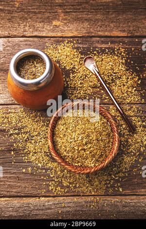 Yerba Mate in Calabash und trockene Kraut in Houten auf Holz- Hintergrund. Ansicht von oben Stockfoto