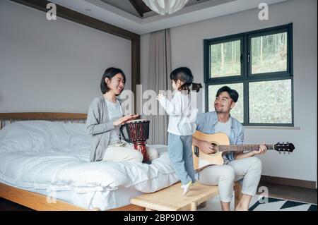 Mama und Papa und Tochter singen zu Hause Stockfoto