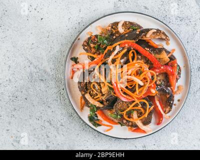Salat eingelegte Auberginen, Möhren, Zwiebeln, Paprika in der Platte auf grauem Zement Hintergrund. Fermentierter Lebensmittel. Konservierte Gemüse. Kopieren Sie Platz für Text. Stockfoto