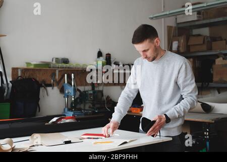 Porträt eines Bekleidungsdesigners oder Ingenieurs in einer generischen Werkstatt. Kleinunternehmen, lokaler Unternehmer, Modeentwicklungskonzept Stockfoto