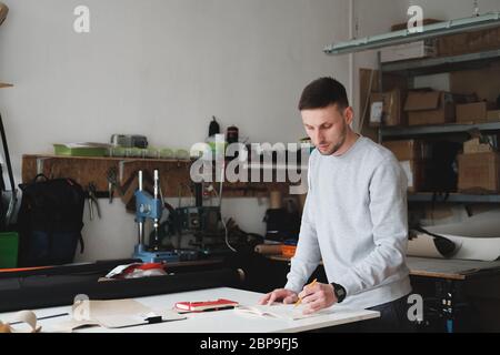 Porträt eines Bekleidungsdesigners oder Ingenieurs in einer generischen Werkstatt. Kleinunternehmen, lokaler Unternehmer, Modeentwicklungskonzept Stockfoto