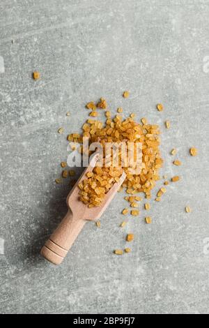 Kristallisiertes brauner Zucker in Holz- Schaufel. Ansicht von oben. Stockfoto