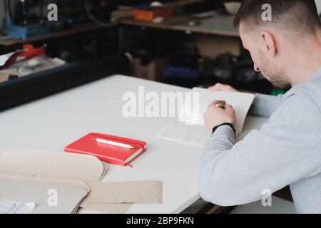 Porträt eines Bekleidungsdesigners oder Ingenieurs in einer generischen Werkstatt. Kleinunternehmen, lokaler Unternehmer, Modeentwicklungskonzept Stockfoto