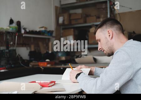 Porträt eines Bekleidungsdesigners oder Ingenieurs in einer generischen Werkstatt. Kleinunternehmen, lokaler Unternehmer, Modeentwicklungskonzept Stockfoto